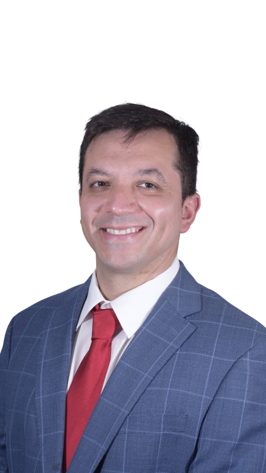 Retrato corporativo de Cristóbal sonriendo con traje formal y corbata sobre un fondo de estudio